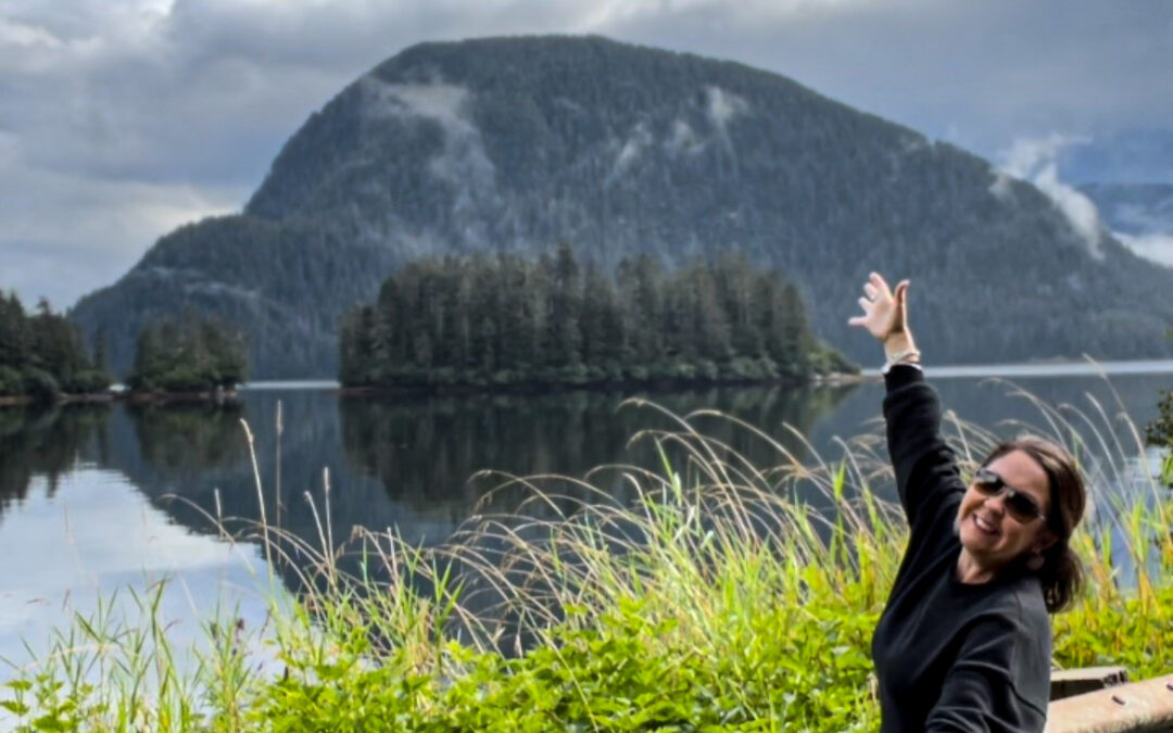 Woman in nature in front of the water and mountain forest in southeastern Alaska